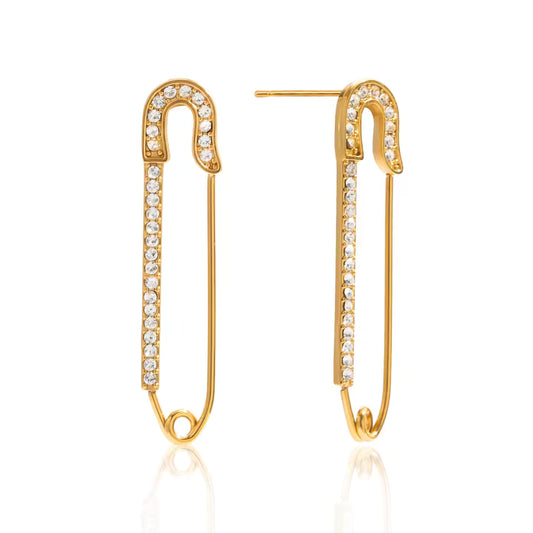 Gold safety pin earrings with clear gemstones on a white background