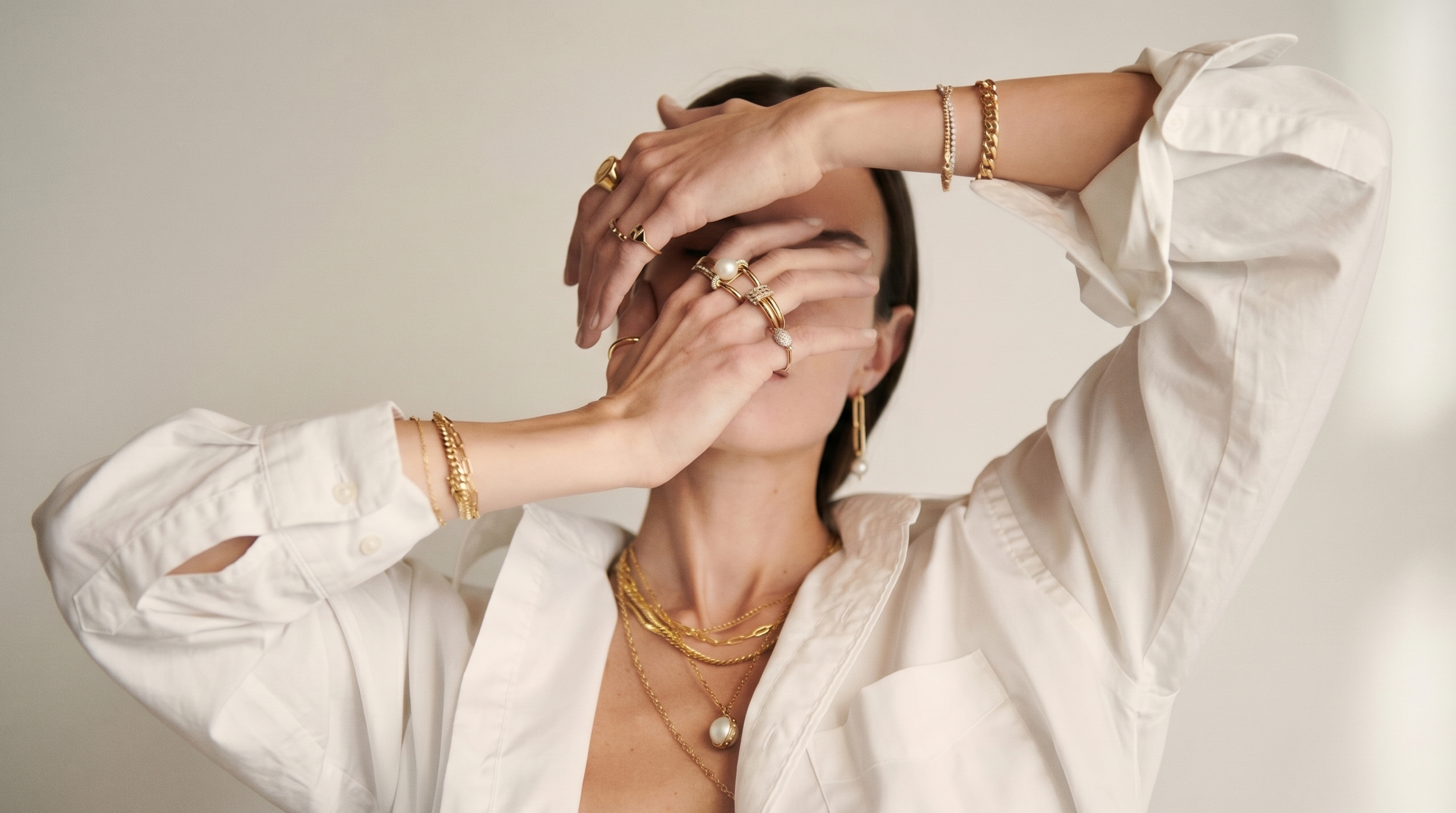 Person wearing gold jewelry with a plain background