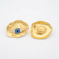 The Horus Studs, hammered gold-tone discs with blue eye, product view | THE ARCIVE